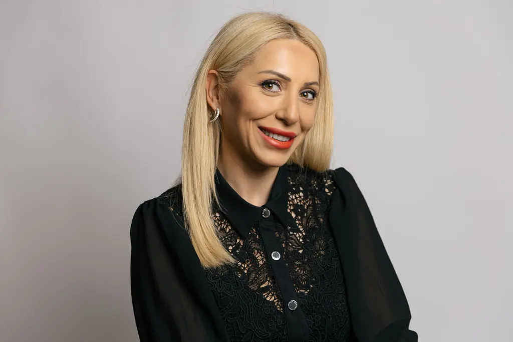 Elizabeta, Creative Director Color und Extensions im Aveda Exclusive Salon by Eddine Belaid, mit langem blondem Haar vor hellgrauem Hintergrund