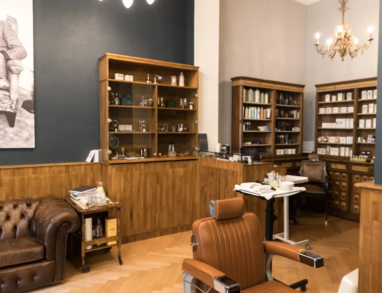 Interior of The Barber Zürich with leather armchairs and wooden shelves
